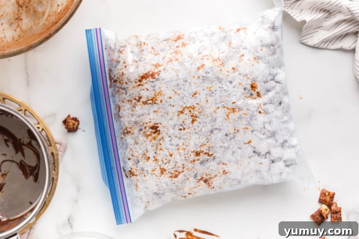 DIY Puppy Chow Perfection 12 Muddy buddies being shaken in a resealable bag to coat with powdered sugar.