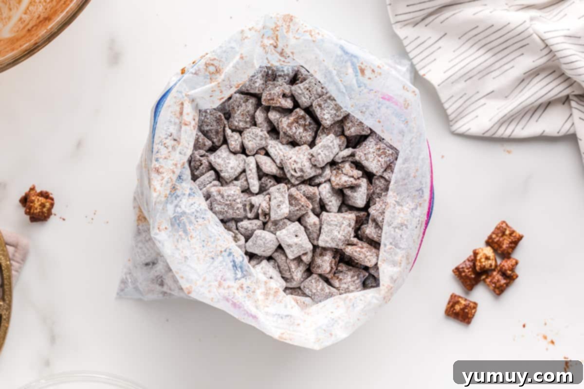DIY Puppy Chow Perfection 13 A bag of homemade puppy chow being poured onto a baking sheet to cool.