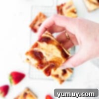Luscious Strawberry Cheesecake Bars 4 Featured strawberry cheesecake bars, showcasing their vibrant color and inviting swirl.