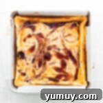 Luscious Strawberry Cheesecake Bars 9 Freshly baked strawberry cheesecake bars in a square baking pan, ready to cool.