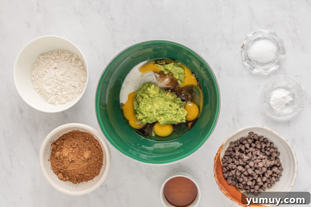 Emerald Fudge Brownies 12 wet ingredients for avocado brownies in a green bowl.