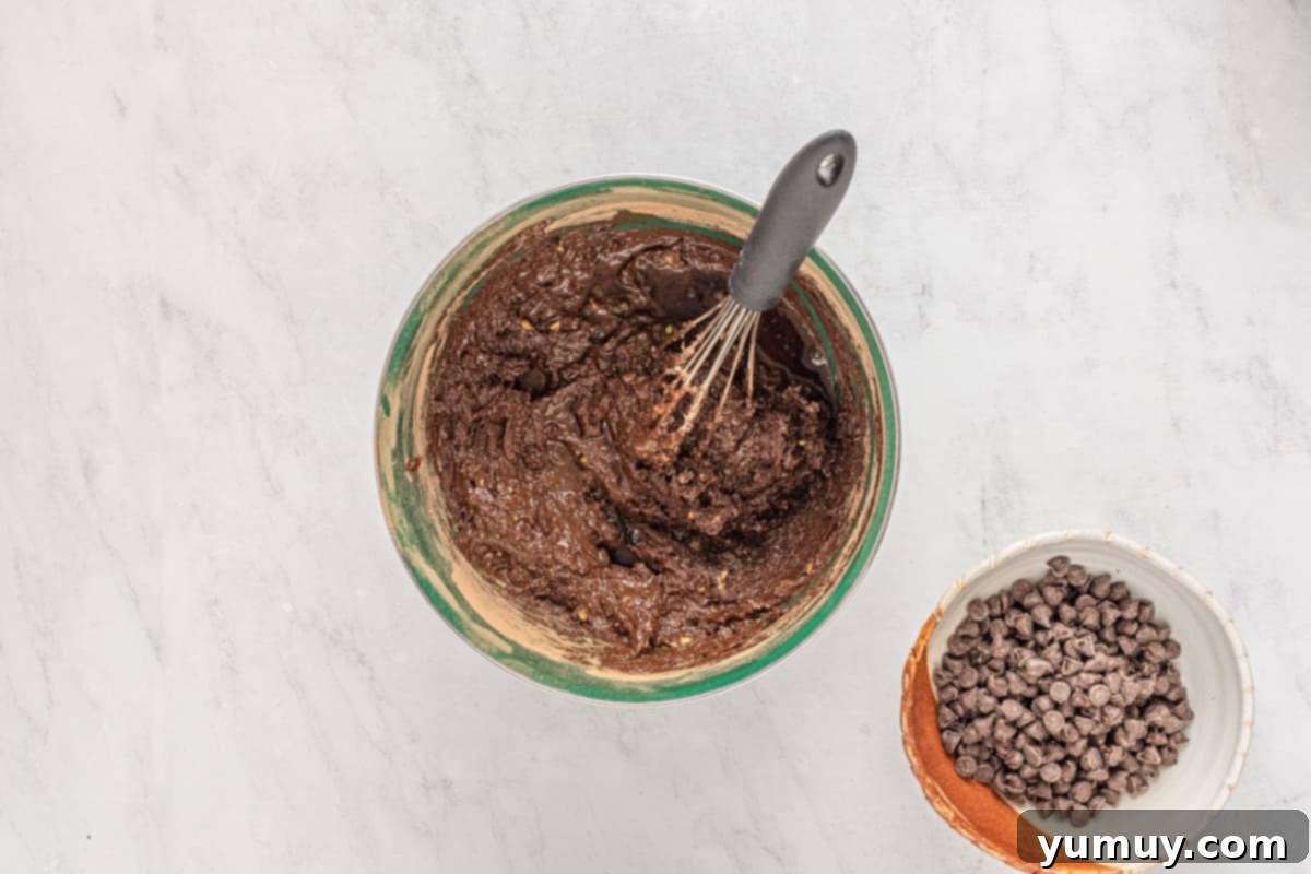 Emerald Fudge Brownies 13 avocado brownie batter in a green bowl with a whisk.