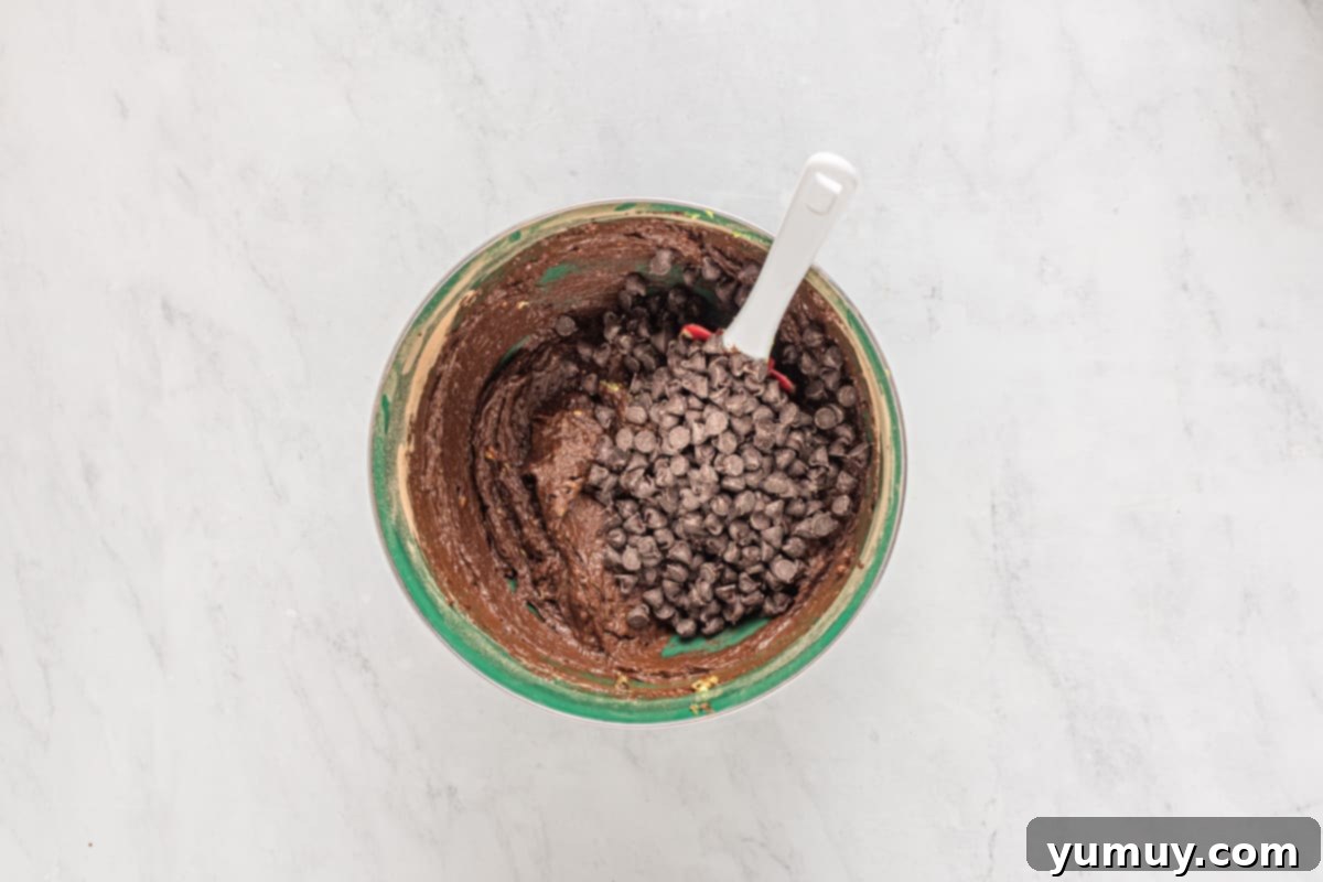 Emerald Fudge Brownies 14 chocolate chips folded into avocado brownie batter with a rubber spatula.