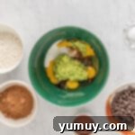 Emerald Fudge Brownies 6 wet ingredients for avocado brownies in a green bowl.