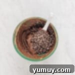 Emerald Fudge Brownies 8 chocolate chips folded into avocado brownie batter with a rubber spatula.