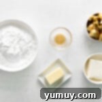 Overhead view of softened butter and cream cheese in a mixing bowl, ready for frosting preparation.