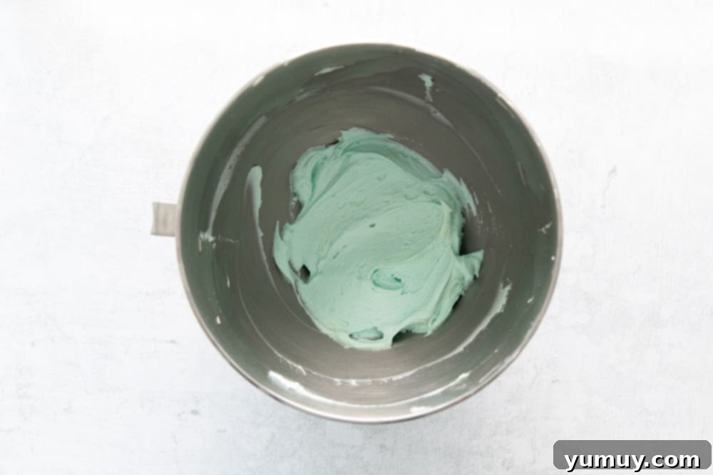 overhead view of robin egg blue frosting in a stainless mixing bowl.