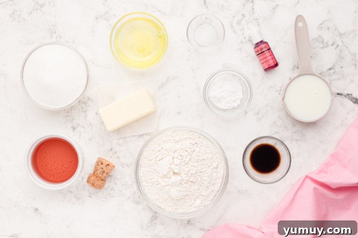 Overhead view of all ingredients for pink moscato cupcakes laid out in individual bowls, ready for baking.