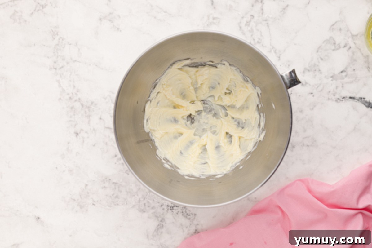 Creamy mixture of beaten shortening and butter in a stainless steel mixing bowl, ideal for making smooth frosting.