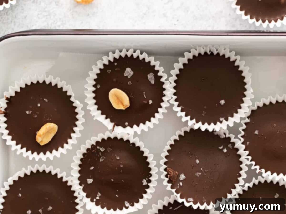 Crunchy Reese's cups in a baking pan, topped with flaky sea salt for a gourmet finish.