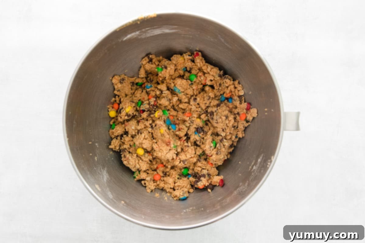 No-Bake Monster Cookie Dough 10 A metal bowl filled with the finished edible cookie dough, rich with M&Ms and chocolate chips, ready for serving.