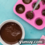 brushing melted chocolate in a half-sphere mold.