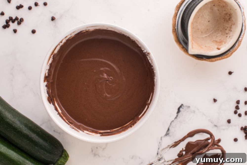Luscious Chocolate Zucchini Bundt 12 Overhead view of the finished chocolate glaze for the bundt cake in a white bowl.