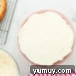 frosting coating a layer of donut cake on a cake stand.
