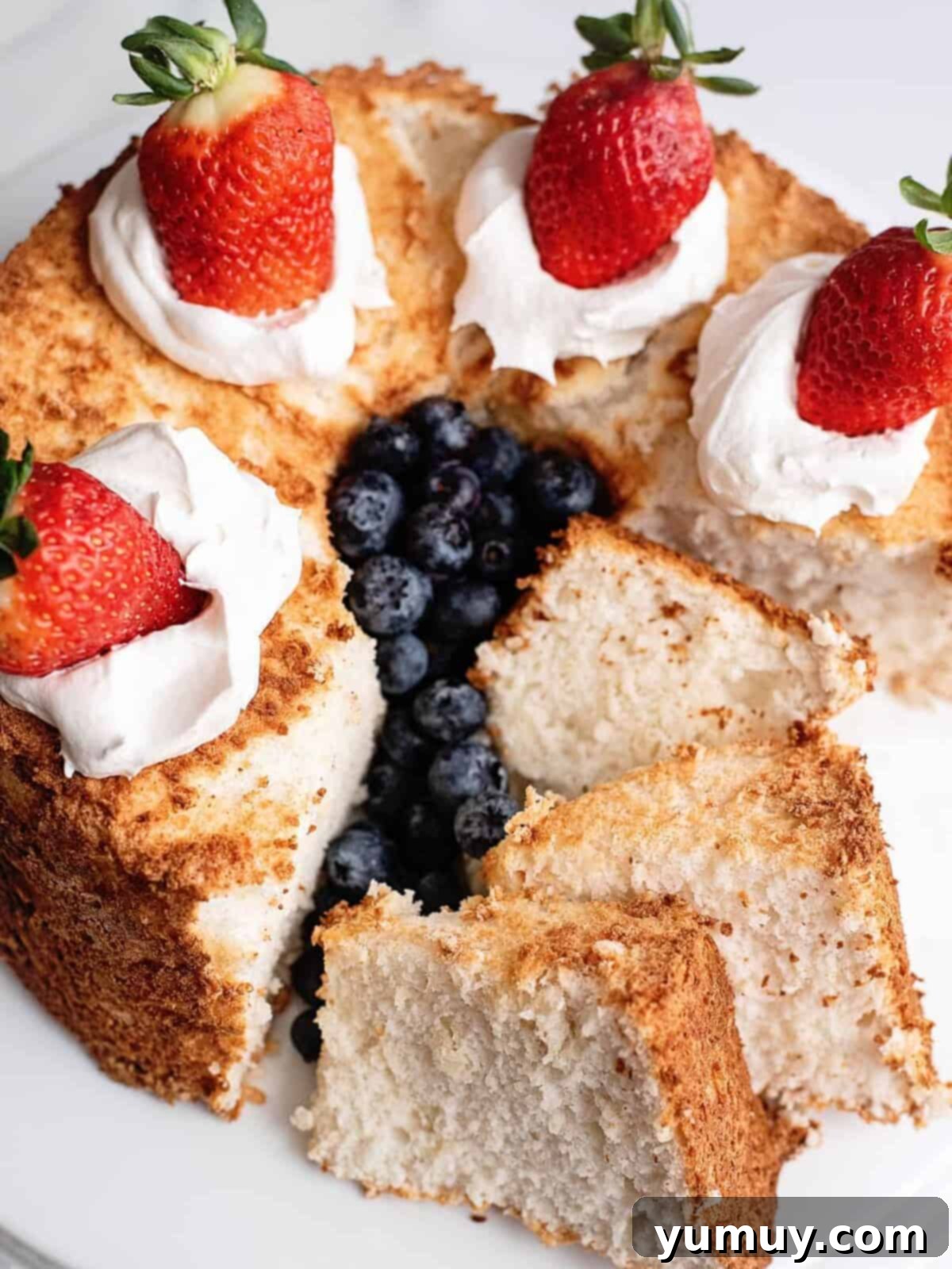 Airy Dream Cake 2 angel food cake sliced and topped with cream and berries