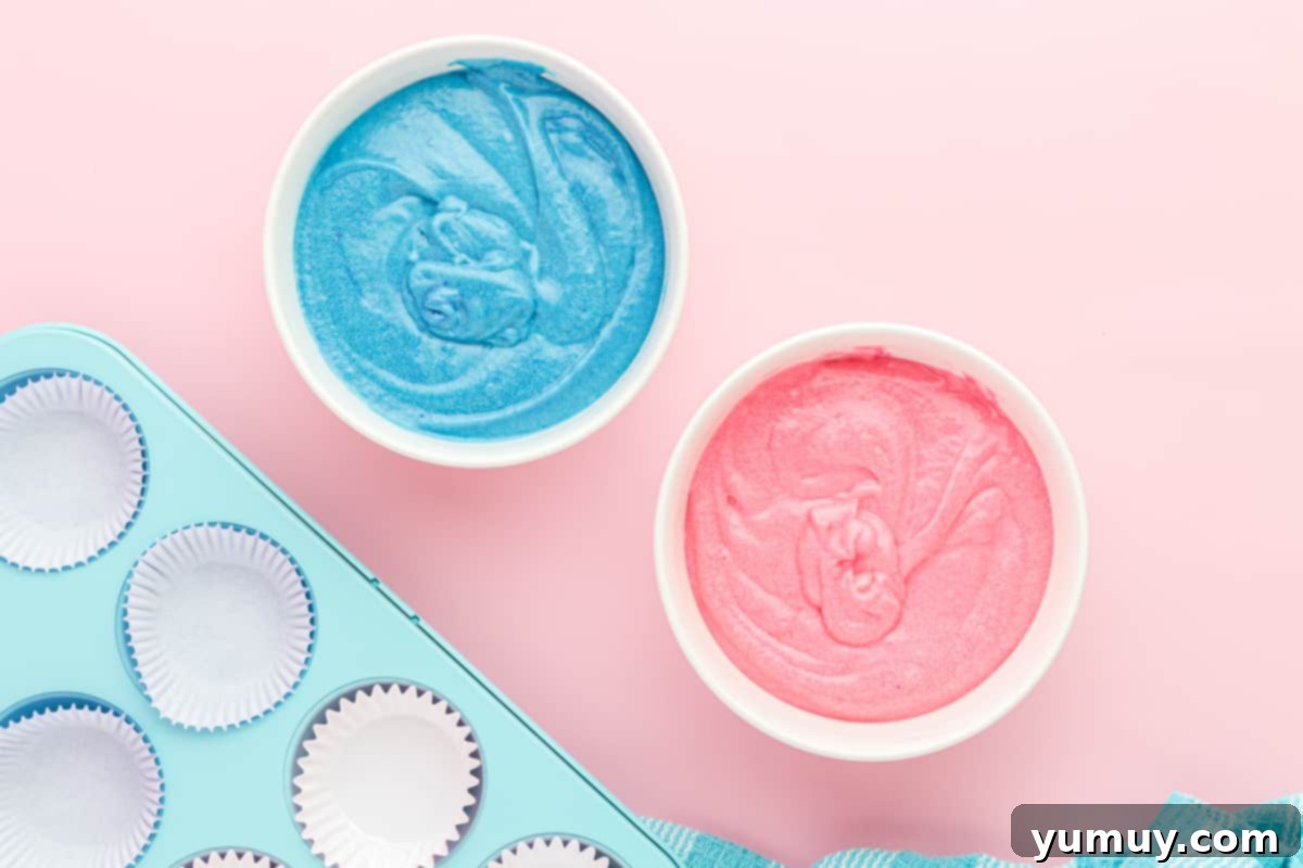 2 bowls of cupcake batter, one colored blue and one colored pink.