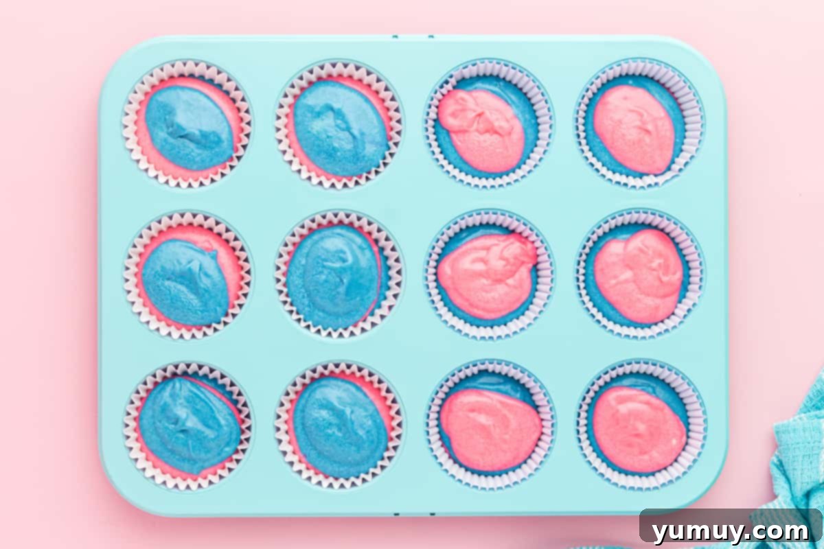 swirled cotton candy cupcake batter in a cupcake tin.