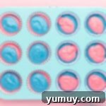 swirled cotton candy cupcake batter in a cupcake tin.