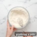 Bursting Blueberry Bundt 6 Dry ingredients for blueberry bundt cake in a glass bowl with a whisk.