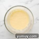 Bursting Blueberry Bundt 8 Wet ingredients for blueberry bundt cake after eggs are added, being mixed.