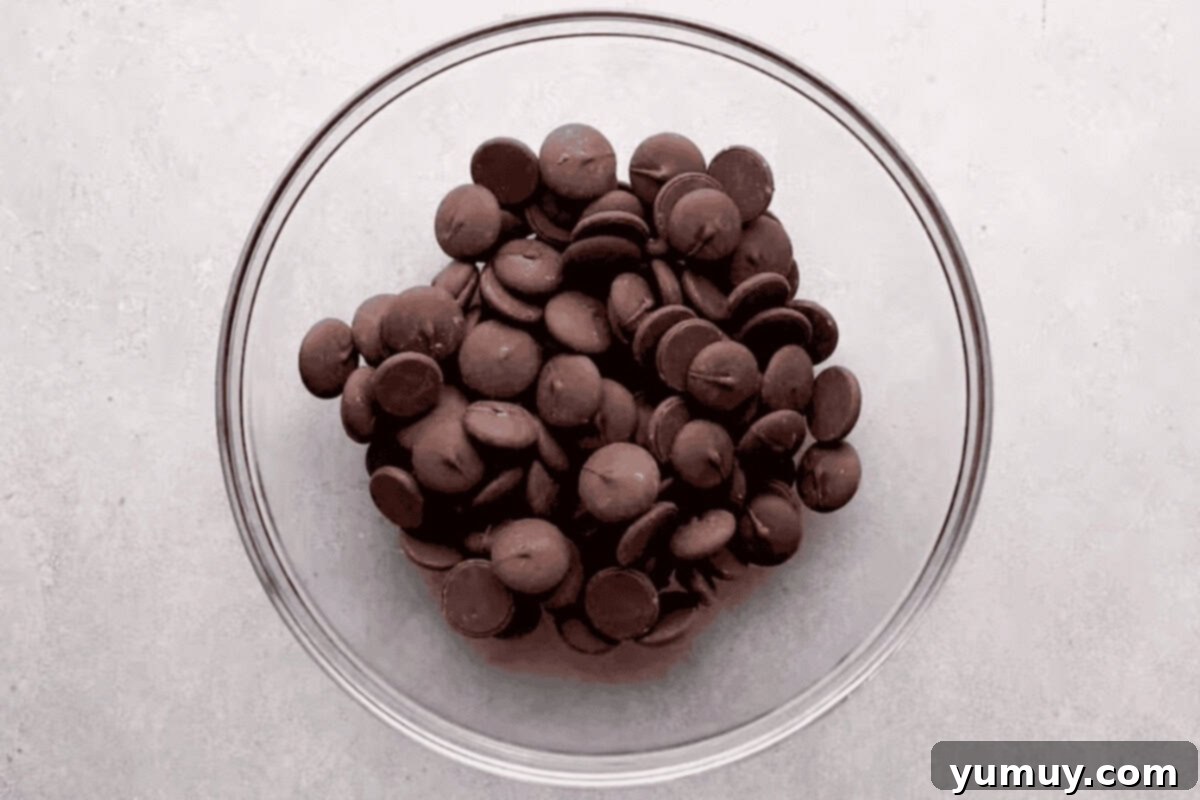 Magical Lucky Charms Hot Cocoa Bombs 11 Melted chocolate wafers in a glass bowl, ready for molding.