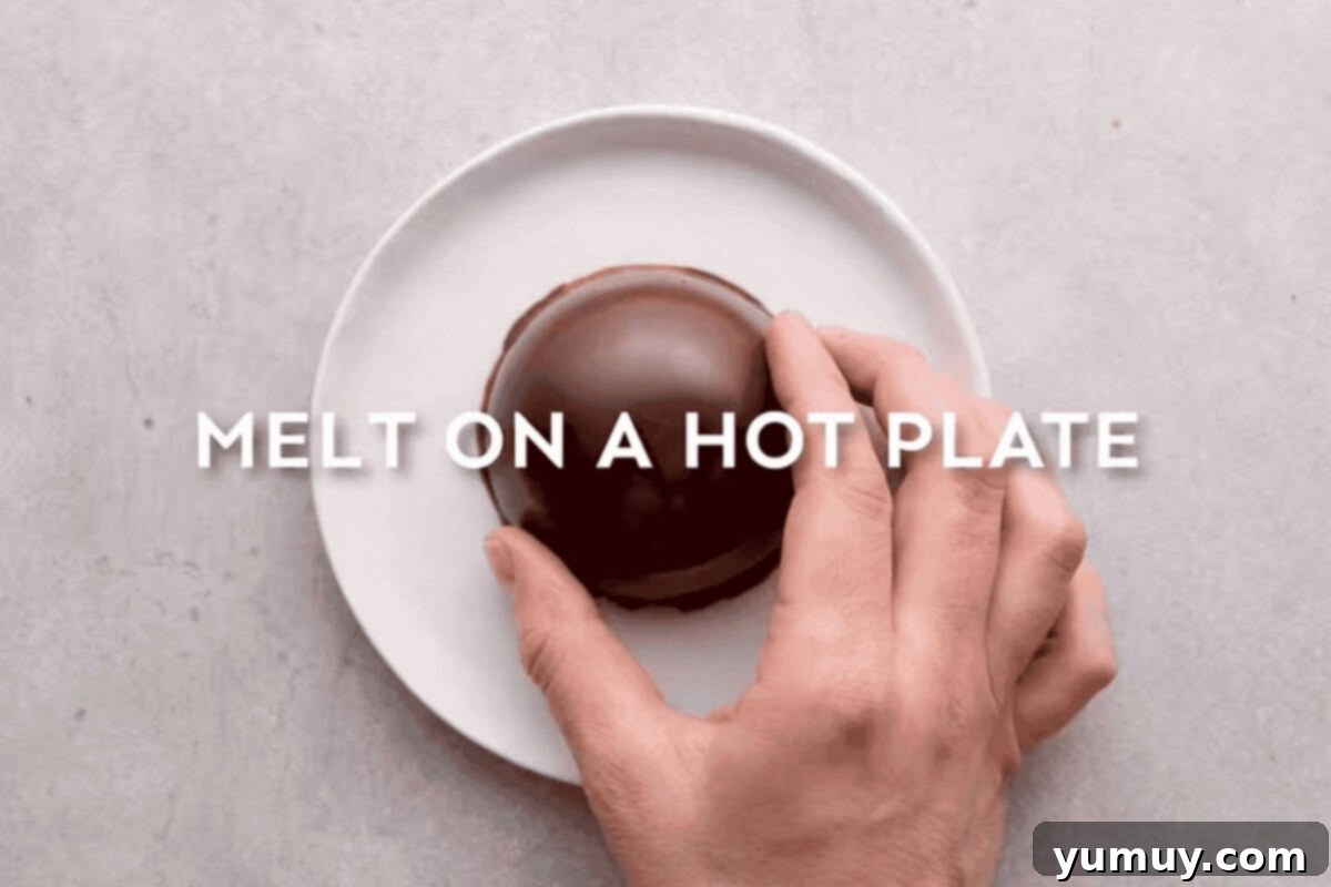 Magical Lucky Charms Hot Cocoa Bombs 14 The edges of a chocolate half-sphere are melted on a warm plate to prepare for sealing.