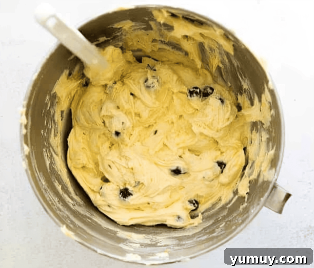 Beautifully mixed blueberry pound cake batter in a stand mixer bowl, ready for baking, with a rubber spatula.