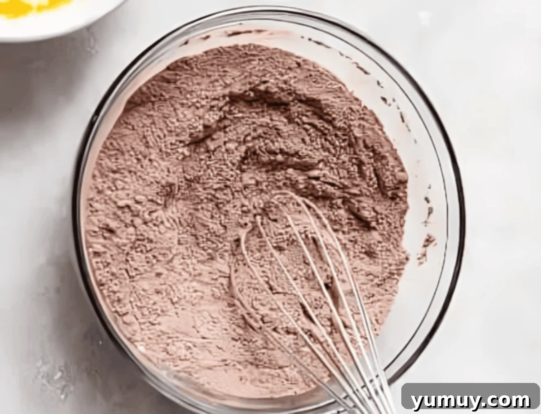 dry chocolate cake mix in a glass bowl with a whisk.
