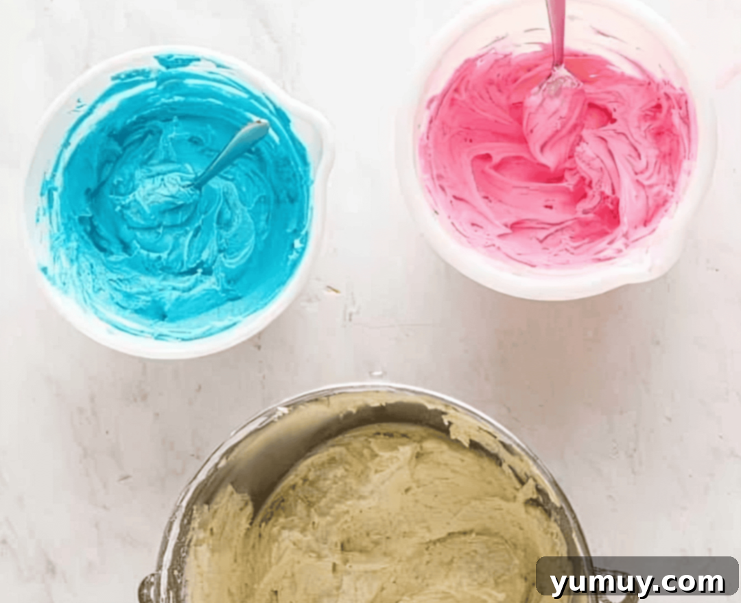 pink, blue, and white buttercream in bowls.