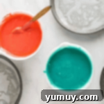 pink and blue cake batter in separate bowls.