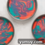 swirled pink and blue cake batter in a round cake pan.