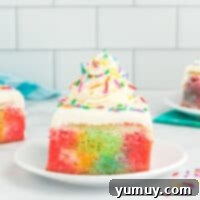 A featured image of the full rainbow poke cake in a rectangular pan, showcasing its smooth, creamy frosting and colorful sprinkles.