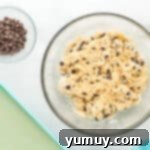 Tropical Coconut Chocolate Chip Delight 8 coconut chocolate chip cookie dough in a glass bowl with chips and coconut mixed in.