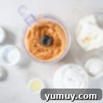 Overhead view of graham cracker crumbs, brown sugar, and melted butter being mixed for the no-bake cheesecake crust.