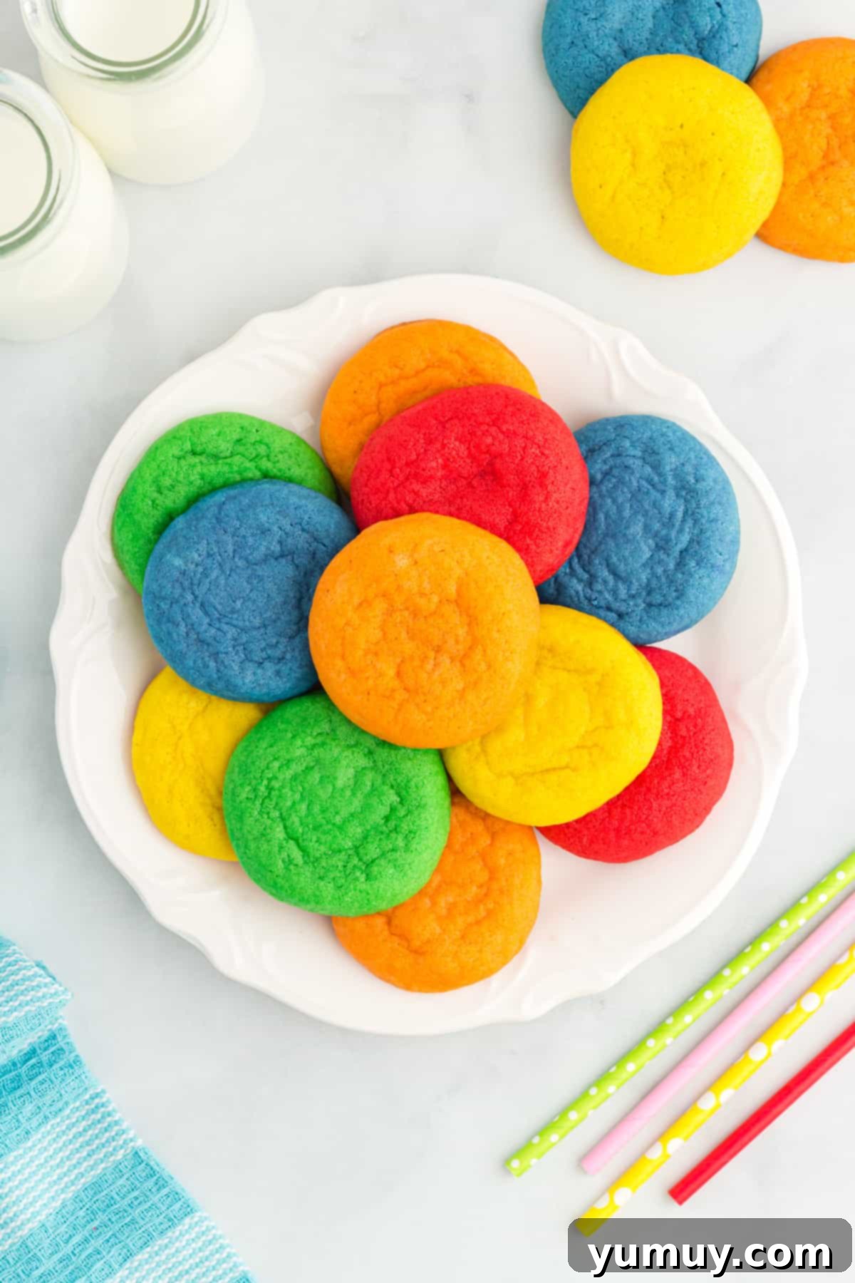 Overhead view of a vibrant assortment of Jello cookies beautifully arranged on a white plate, showcasing their rich colors.