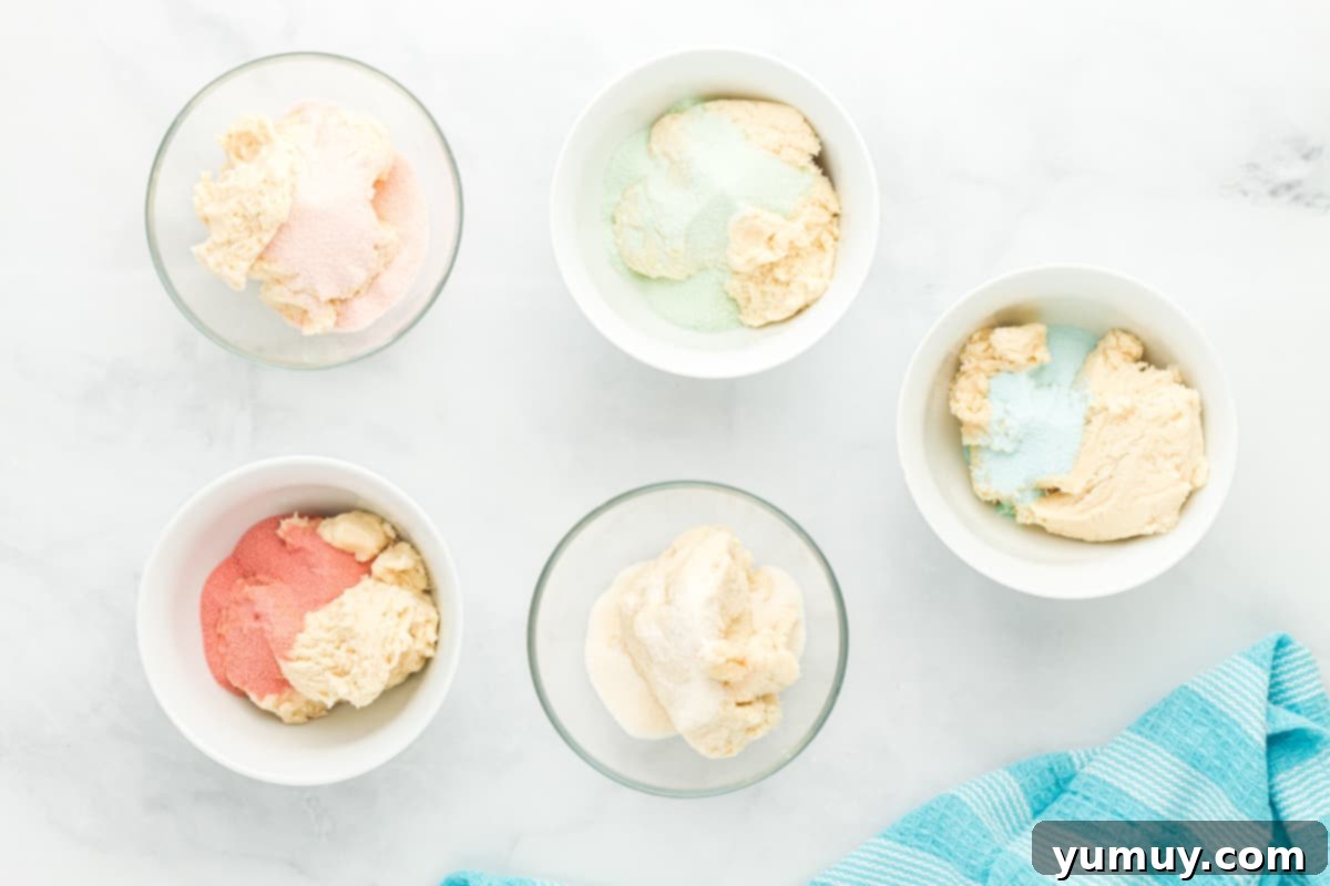 Dry Jell-O mix sprinkled into individual bowls of cookie dough, ready for coloring.