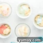 Dry Jell-O mix being added to individual bowls of cookie dough, ready for coloring.