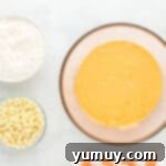 jello, ice cream, and orange zest added to creamed butter and sugar in a glass bowl.