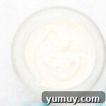 Effortless Red Velvet Cake from a Mix 11 cream cheese frosting in a glass bowl.