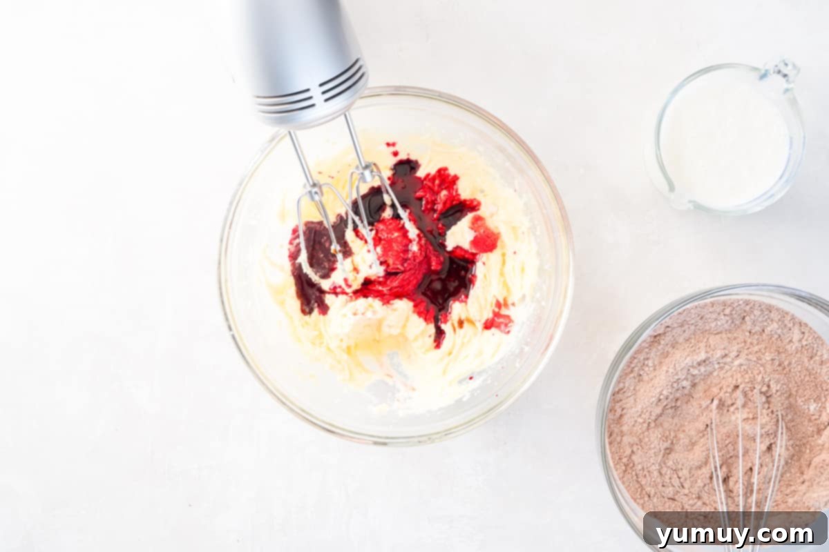 Effortless Red Velvet Cake from a Mix 17 food coloring added to red velvet cake batter with a hand mixer.