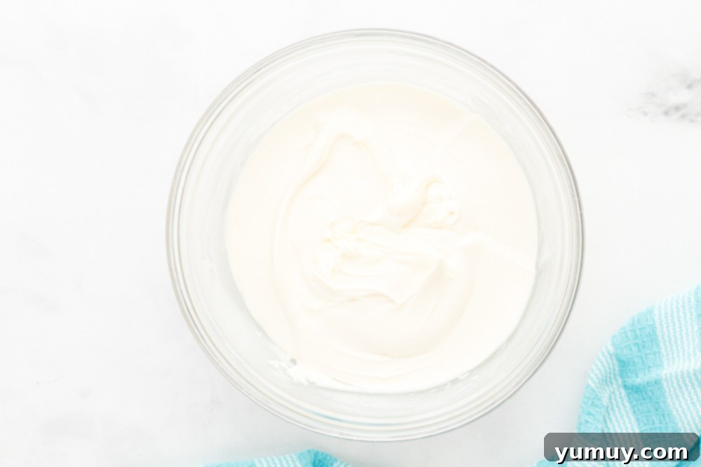 Effortless Red Velvet Cake from a Mix 21 cream cheese frosting in a glass bowl.