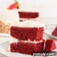 Effortless Red Velvet Cake from a Mix 4 side view of a partially eaten slice of red velvet cake on a white plate.
