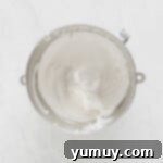 Layered S'mores Delight 6 whipped cream in a bowl on a marble countertop.