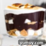 Layered S'mores Delight 9 layered smores trifle in glass dish with ingredients in back