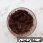 Creamed butter and cocoa in a glass bowl.