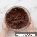 Whipped chocolate buttercream frosting in a glass bowl.