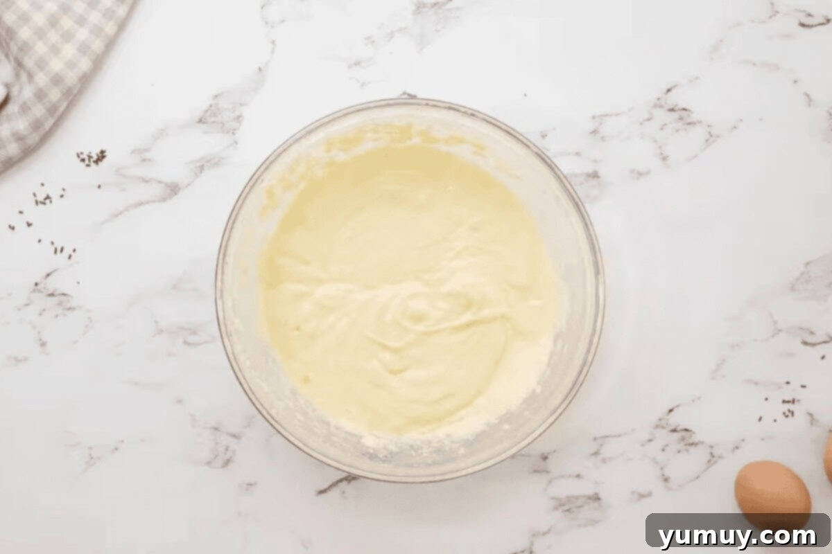 Close-up of creamy cake batter in a glass bowl, showcasing the rich, smooth texture.