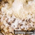 Pouring powdered sugar and cake mix over the chocolate and sprinkle coated Chex cereal.