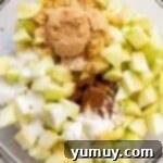 Homestyle Dutch Apple Pie 6 chopped apples and spices in a glass bowl.