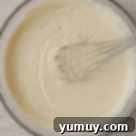 Sunshine Slice 6 key lime pie filling in a glass bowl with a whisk.